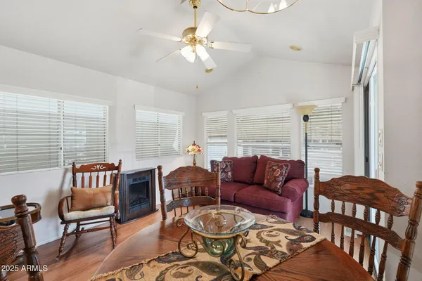 a living room with furniture two lamps and wooden floor