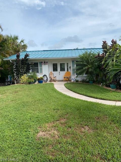 172 Riverwood Road Naples, FL 34114 - Photo 5 of 49 a front view of a house with garden and trees