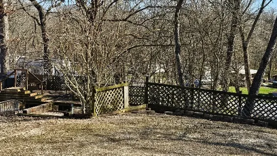 a view of a yard with wooden fence