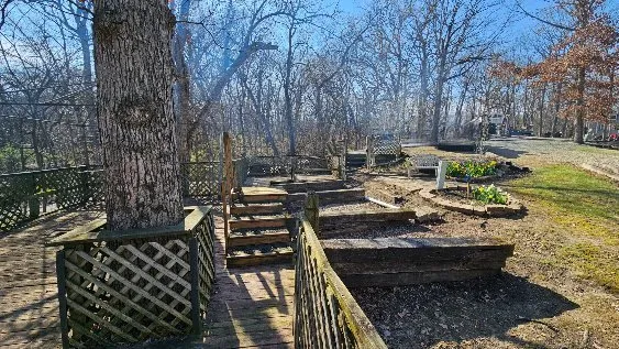 a view of a wooden deck with chairs and trees