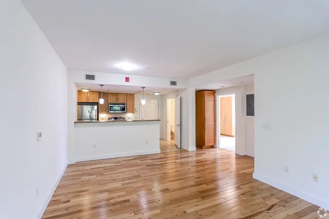 a view of a hallway with wooden floor and a cabinet