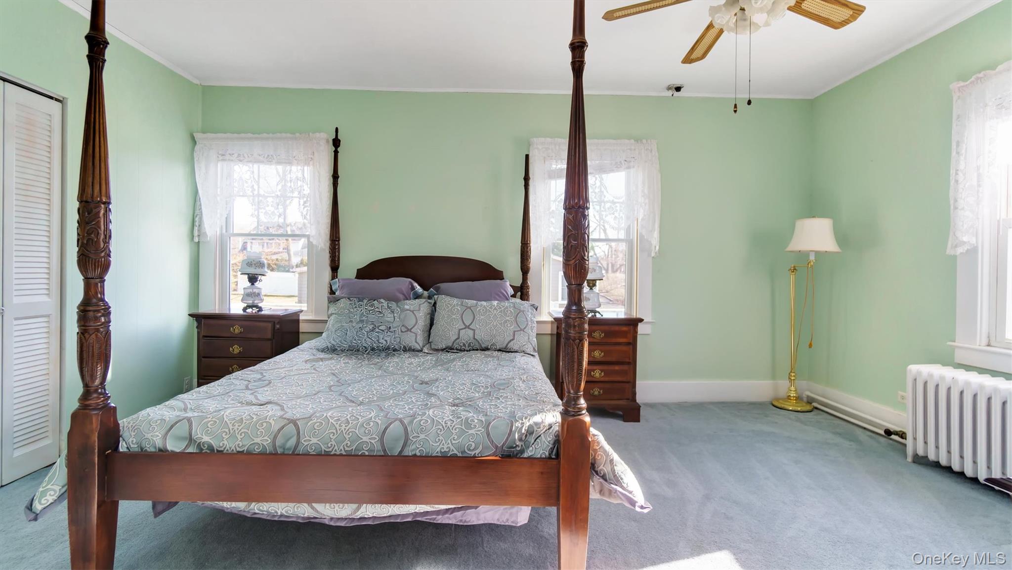 280 Wickham Avenue Mattituck, NY 11952 - Photo 28 of 41 a bedroom with a bed and a chandelier