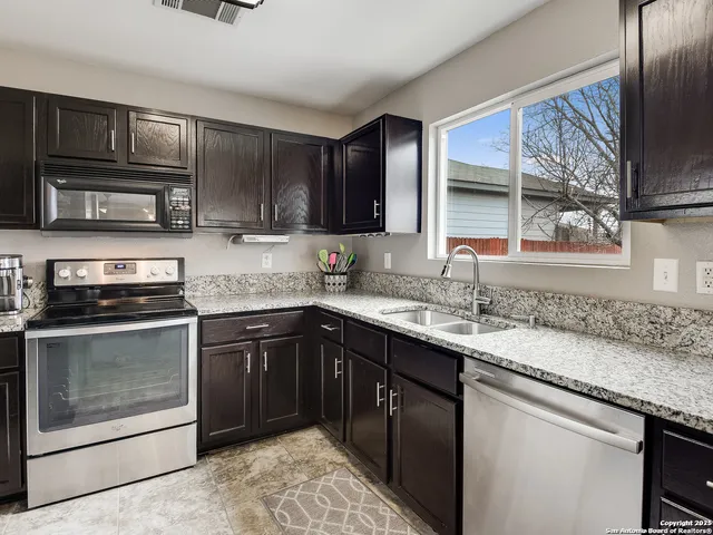 a kitchen with stainless steel appliances granite countertop a sink stove and microwave