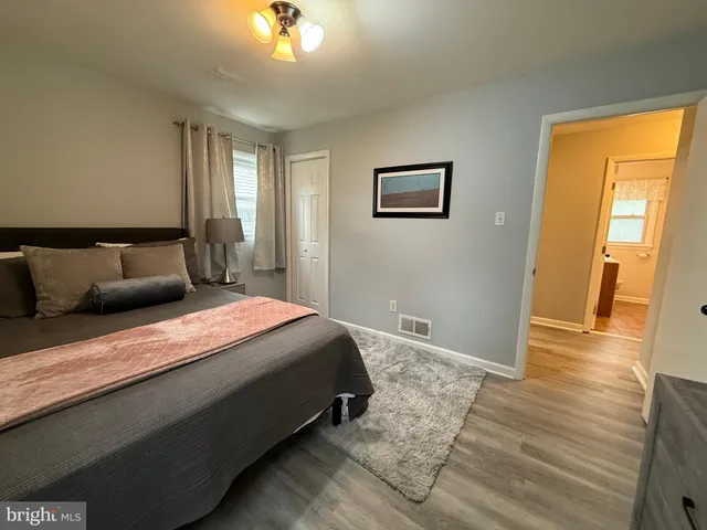 a bedroom with bed and wooden floor