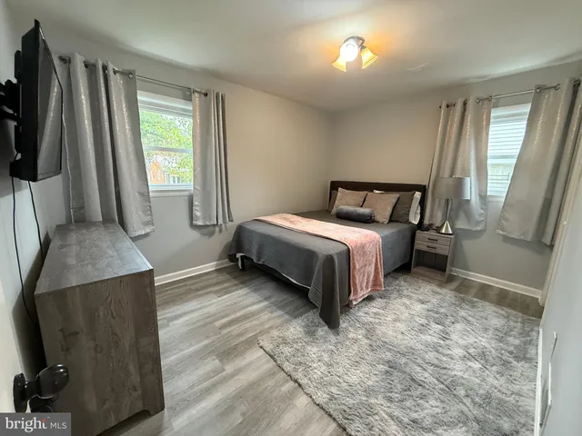 a bedroom with a bed and a flat tv screen on the dresser