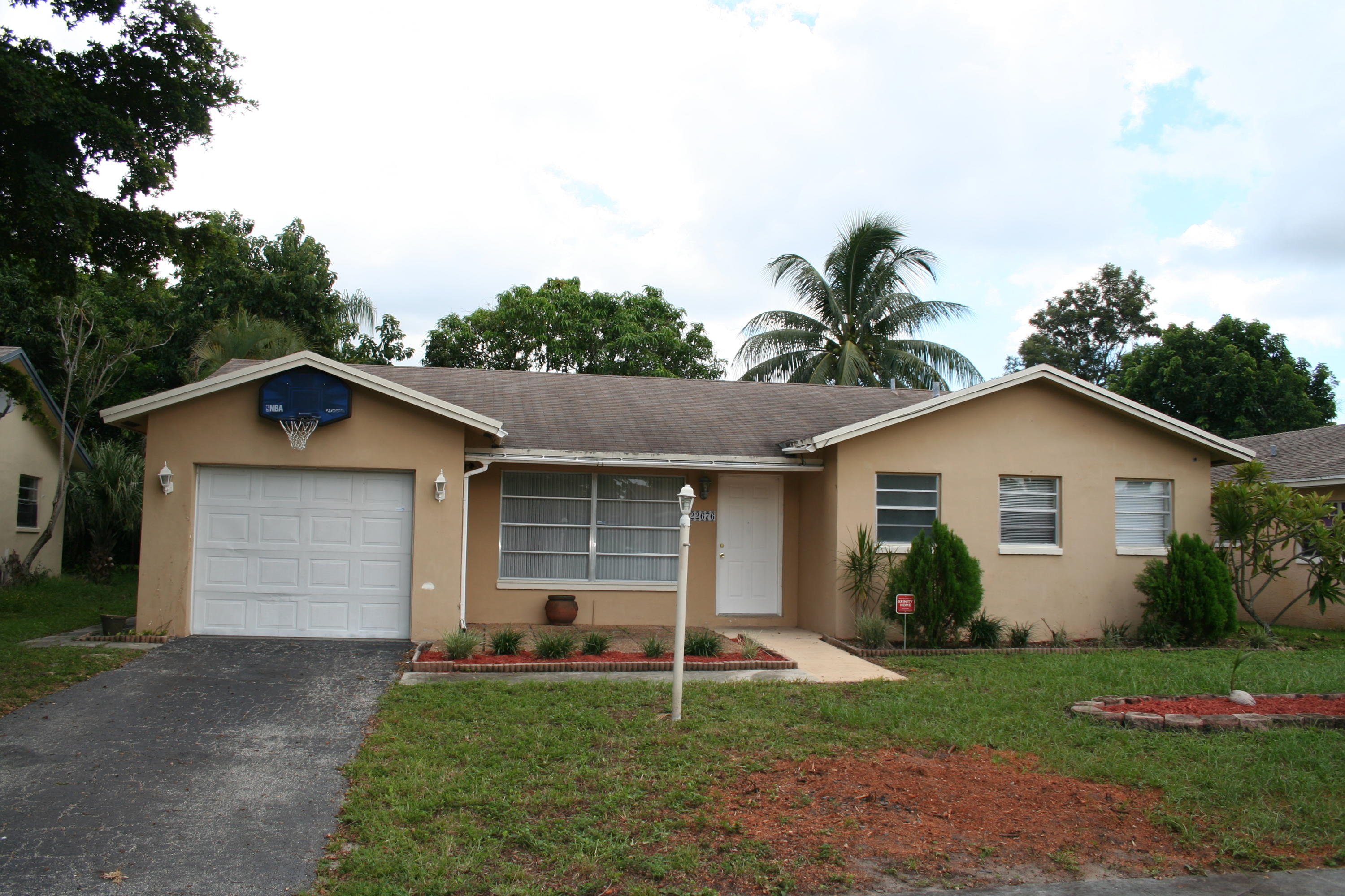 22676 Southwest 65th Terrace Boca Raton, FL 33428 - Photo 12 of 12 a white house with a small yard and a large window