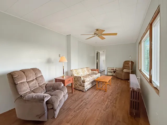 a living room with furniture two couches and a large window