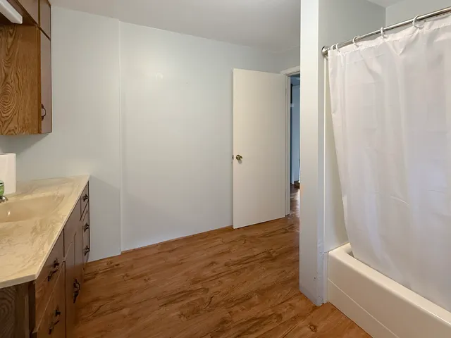 a bathroom with a granite countertop sink and a bathtub