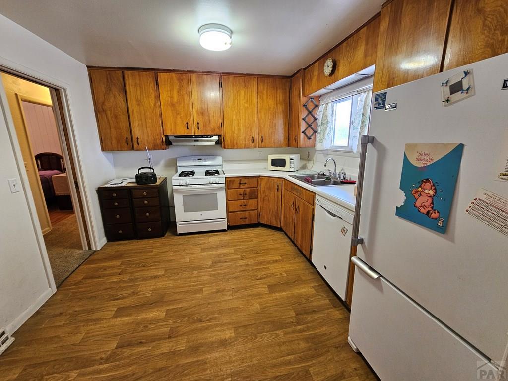 900 Rittgers Street Eads, CO 81036 - Photo 9 of 35 a kitchen with granite countertop a refrigerator a sink dishwasher stove and wooden cabinets
