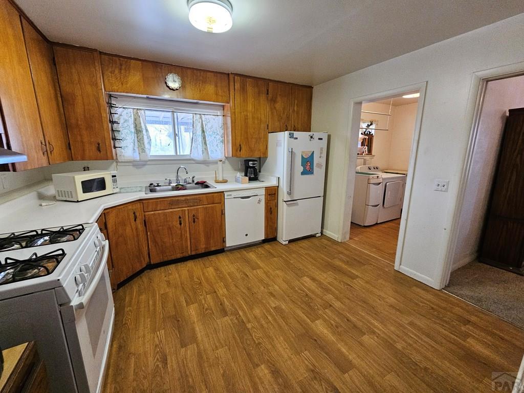 900 Rittgers Street Eads, CO 81036 - Photo 10 of 35 a kitchen with a refrigerator a sink dishwasher and wooden cabinets