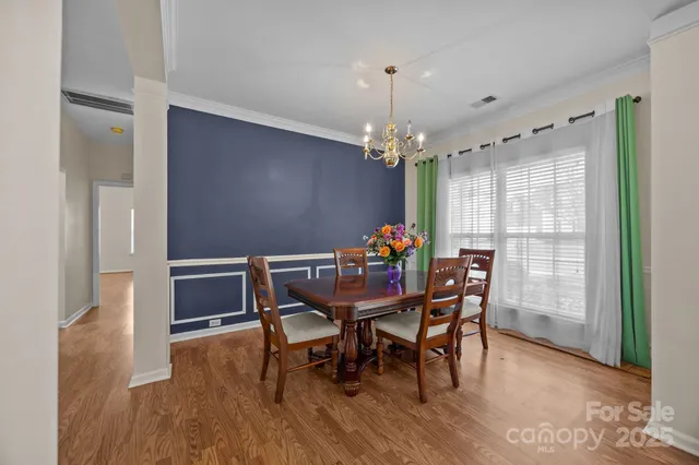 a dining room with furniture a chandelier and wooden floor