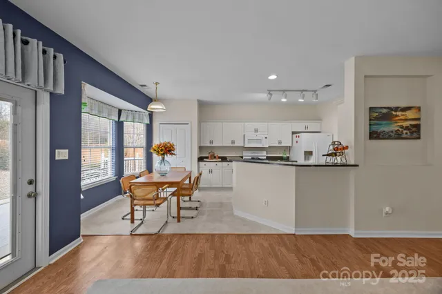 a living room with furniture and a dining table with kitchen view