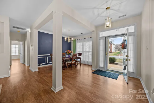 a view of a livingroom with wooden floor and a kitchen space