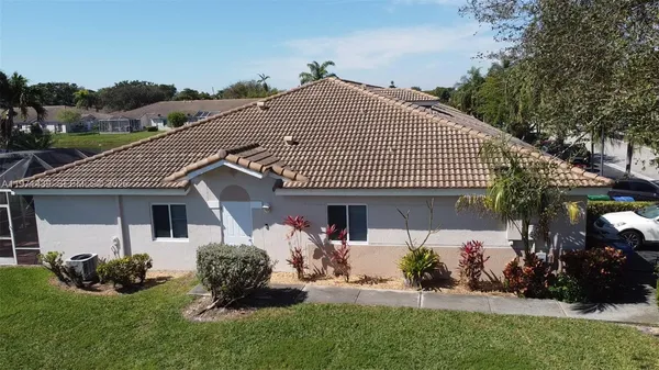 a front view of a house with a garden and plants