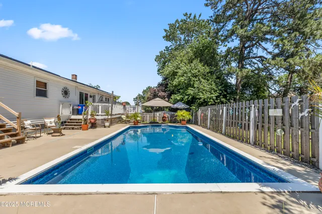 a swimming pool with outdoor seating and yard