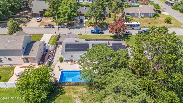 an aerial view of residential houses with outdoor space and trees