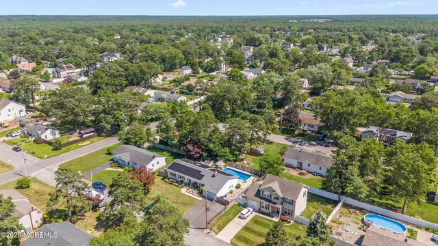an aerial view of residential houses with outdoor space and trees