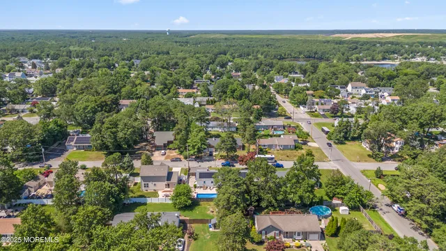 an aerial view of residential houses with outdoor space and trees