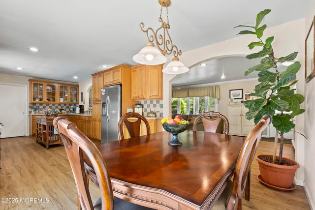 a dining room with furniture potted plants and wooden floor