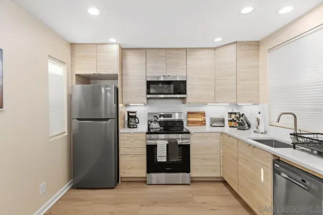 a kitchen with stainless steel appliances granite countertop a refrigerator stove a sink and a microwave