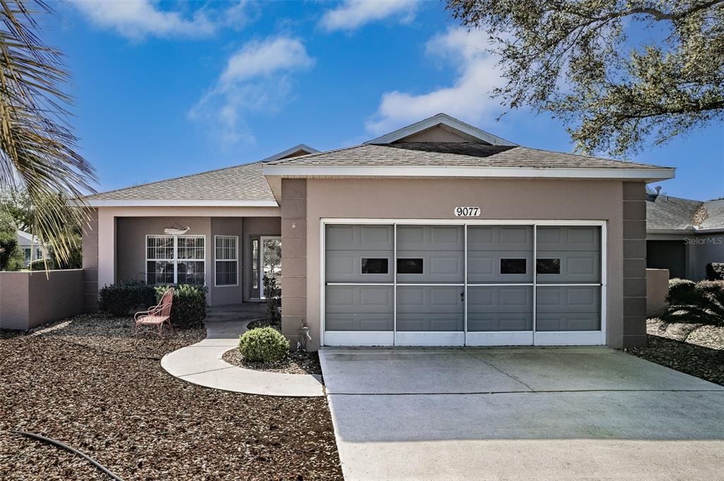 9077 Southwest 95th Terrace Ocala, FL 34481 - Photo 1 of 45 a front view of a house with a yard and garage