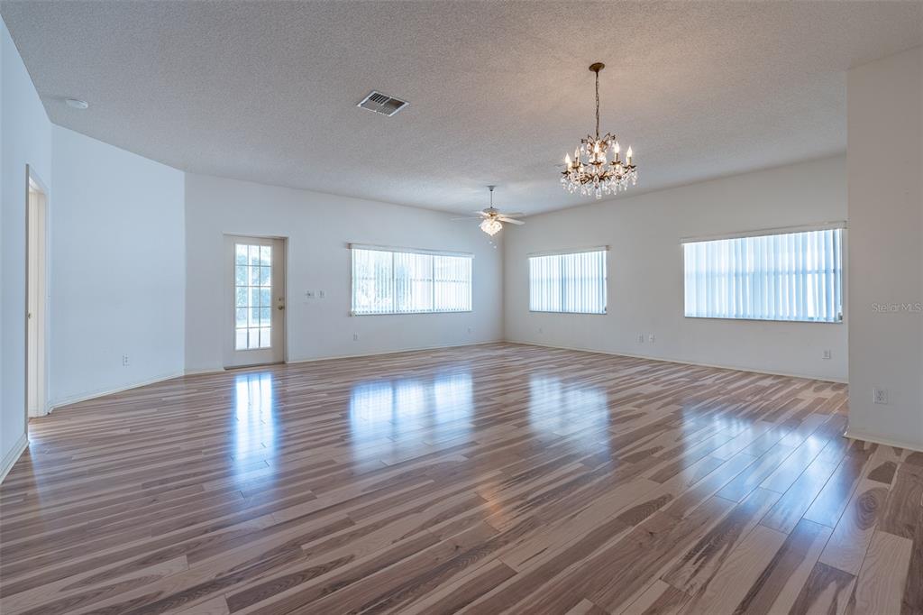 9077 Southwest 95th Terrace Ocala, FL 34481 - Photo 5 of 45 a view of an empty room with wooden floor and a window