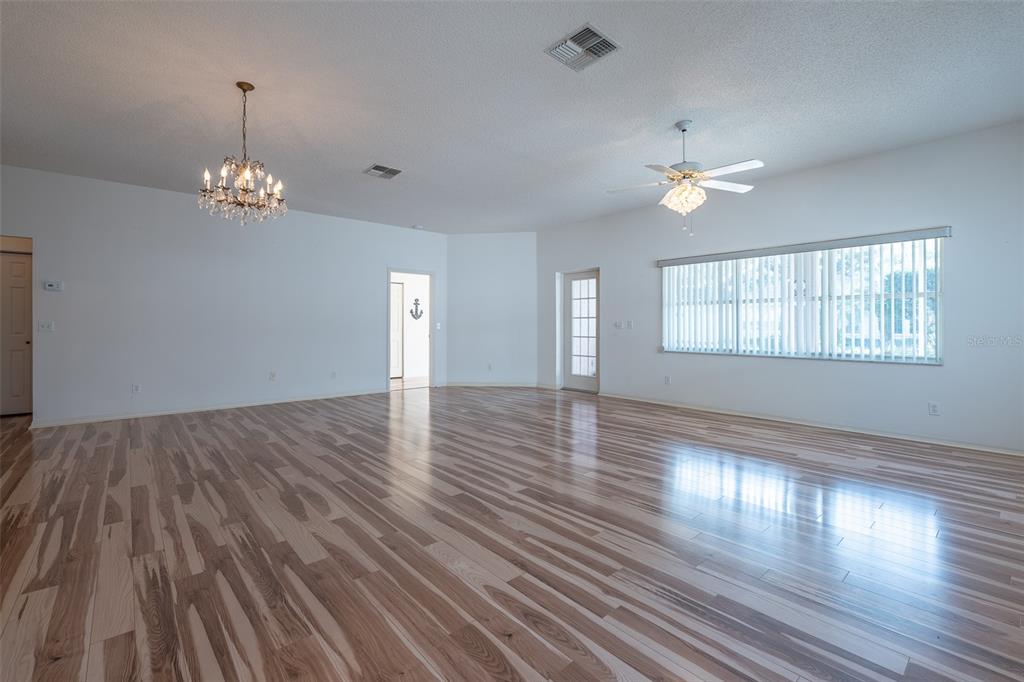 9077 Southwest 95th Terrace Ocala, FL 34481 - Photo 6 of 45 a view of empty room with wooden floor and fan