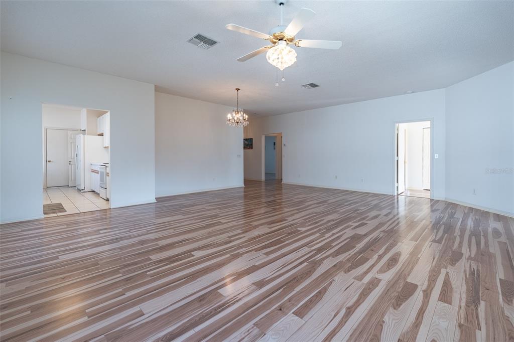 9077 Southwest 95th Terrace Ocala, FL 34481 - Photo 7 of 45 a view of empty room with wooden floor and ceiling fan