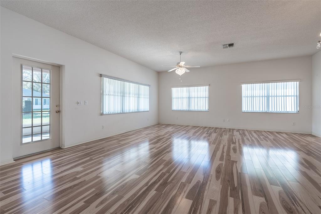 9077 Southwest 95th Terrace Ocala, FL 34481 - Photo 9 of 45 an empty room with wooden floor and windows
