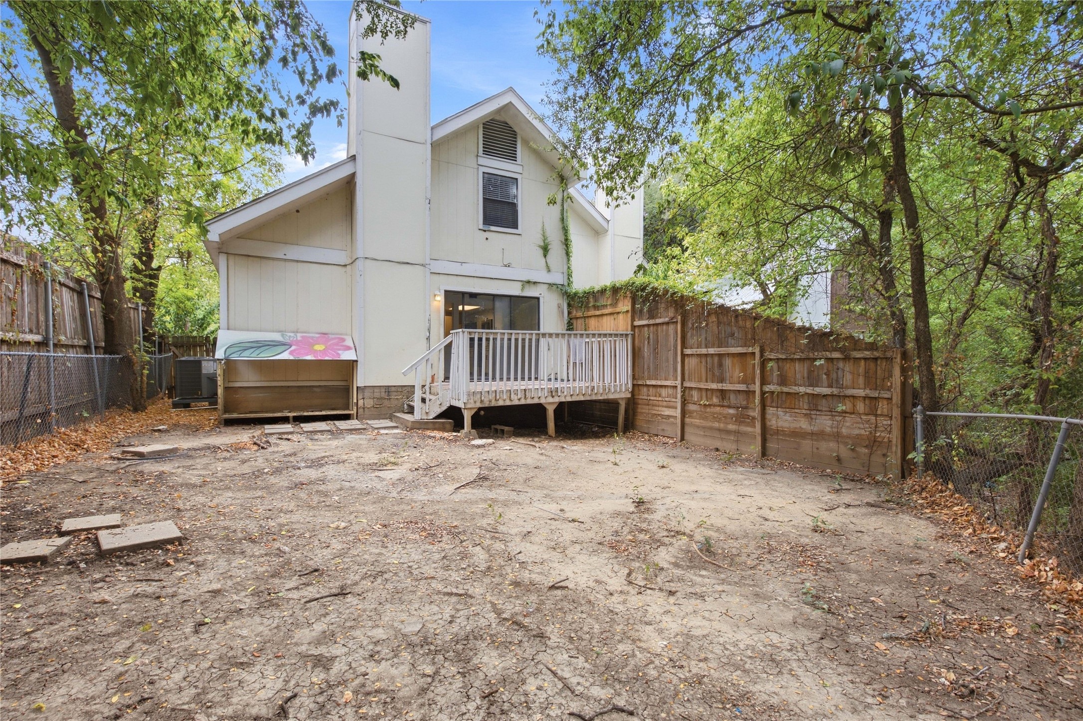 2500 Jones Road, Unit B Austin, TX 78745 - Photo 18 of 37 Mature trees frame the back exterior, which includes a wooden deck and privacy fencing.