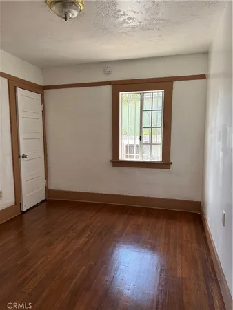 a kitchen with granite countertop wooden floors wooden cabinets a sink and a window
