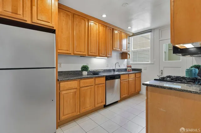 a kitchen with stainless steel appliances granite countertop a refrigerator sink and cabinets