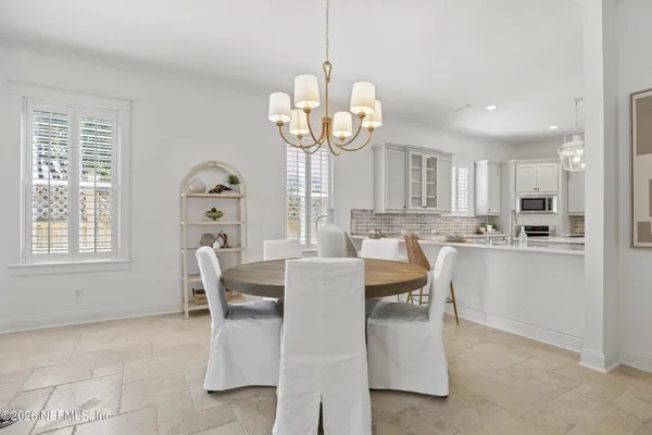 a view of kitchen with dining area refrigerator and window