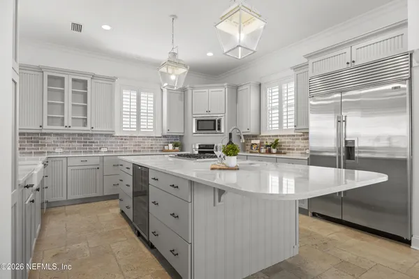a large white kitchen with a large window