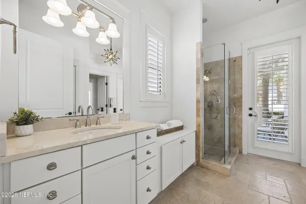 a bathroom with a double vanity sink mirror and shower