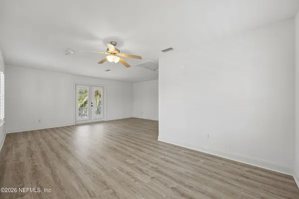 an empty room with wooden floor and windows