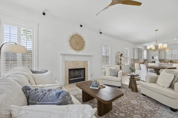 a living room with furniture a fireplace and a large window