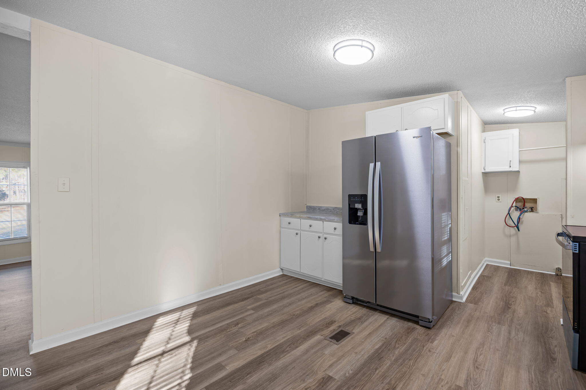 91 Pine Ridge Road Henderson, NC 27537 - Photo 17 of 50 a kitchen with a refrigerator and a wooden floor