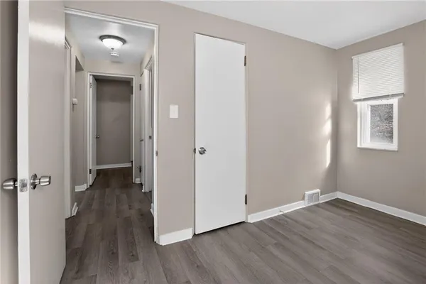 a view of a hallway with wooden floor and closet