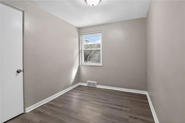 a view of a small space with wooden floor and a window