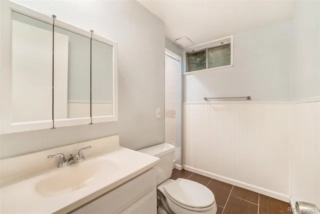 a bathroom with a granite countertop sink a toilet a mirror and shower