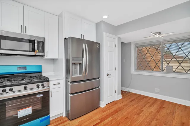 a view of a kitchen with wooden floor and electronic appliances