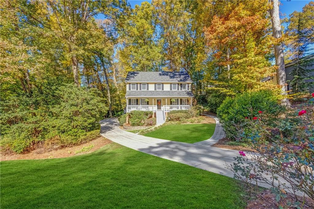 a view of a big yard in front of a house with a large tree