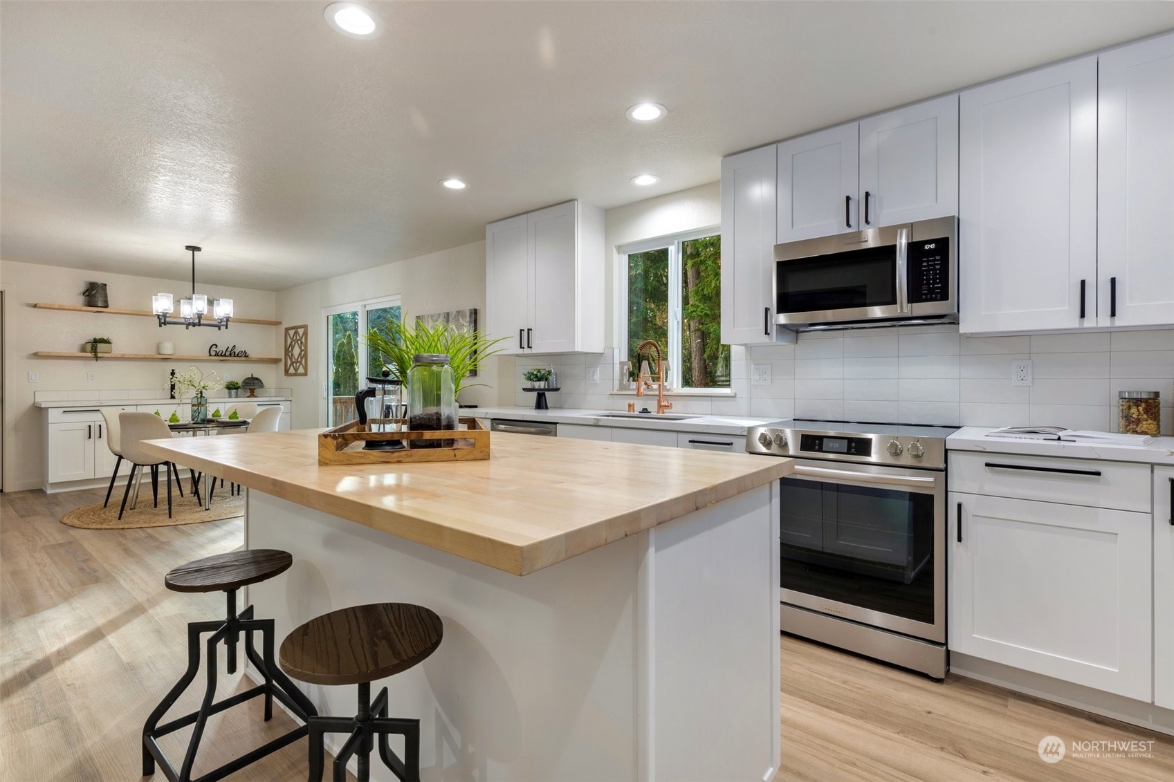 17728 28th Avenue Southeast Bothell, WA 98012 - Photo 16 of 40 a kitchen with stainless steel appliances kitchen island granite countertop a sink and a stove top oven with wooden floor