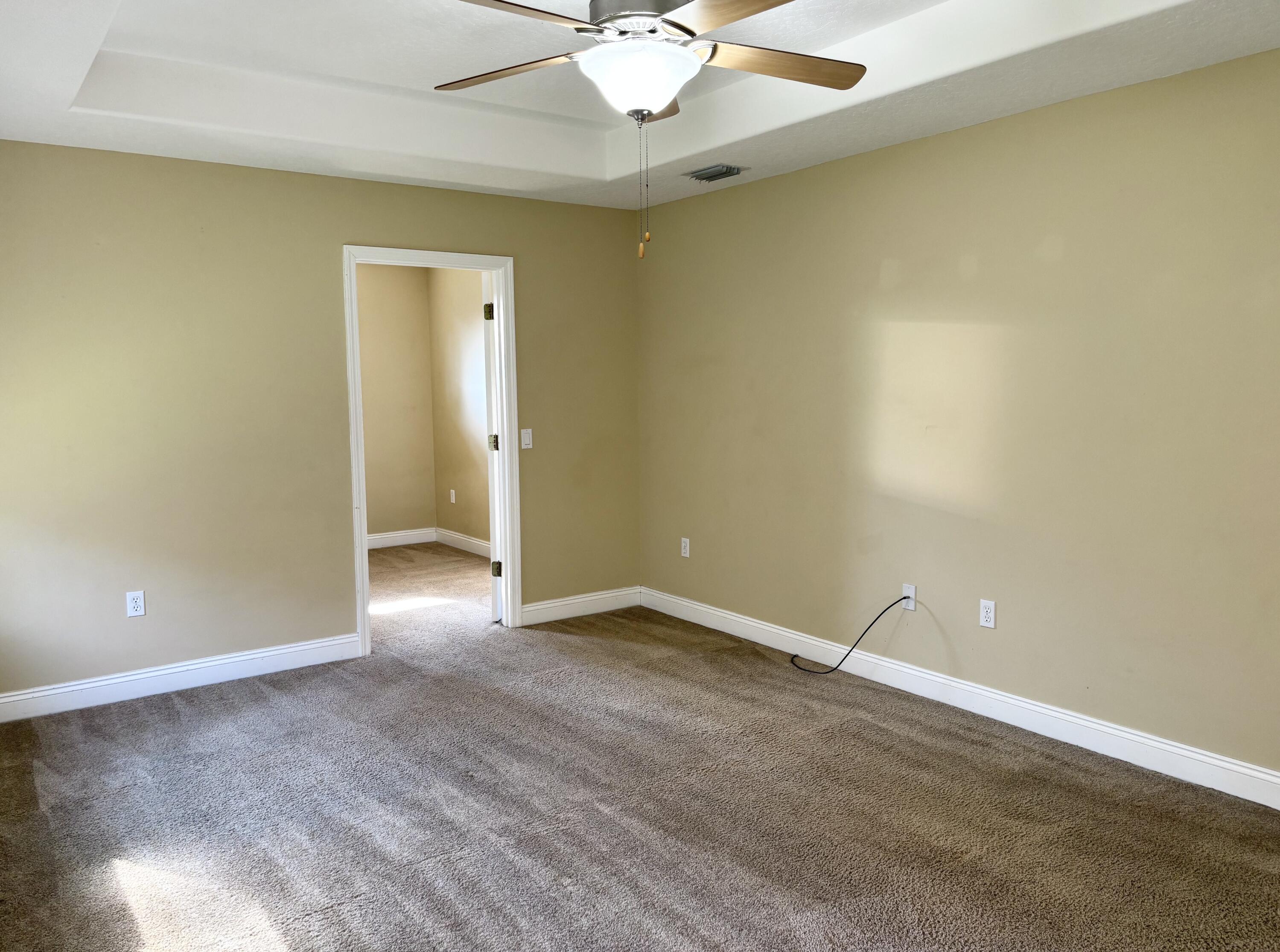 9561 Pouder Lane Navarre, FL 32566 - Photo 11 of 20 an empty room with a chandelier fan and windows