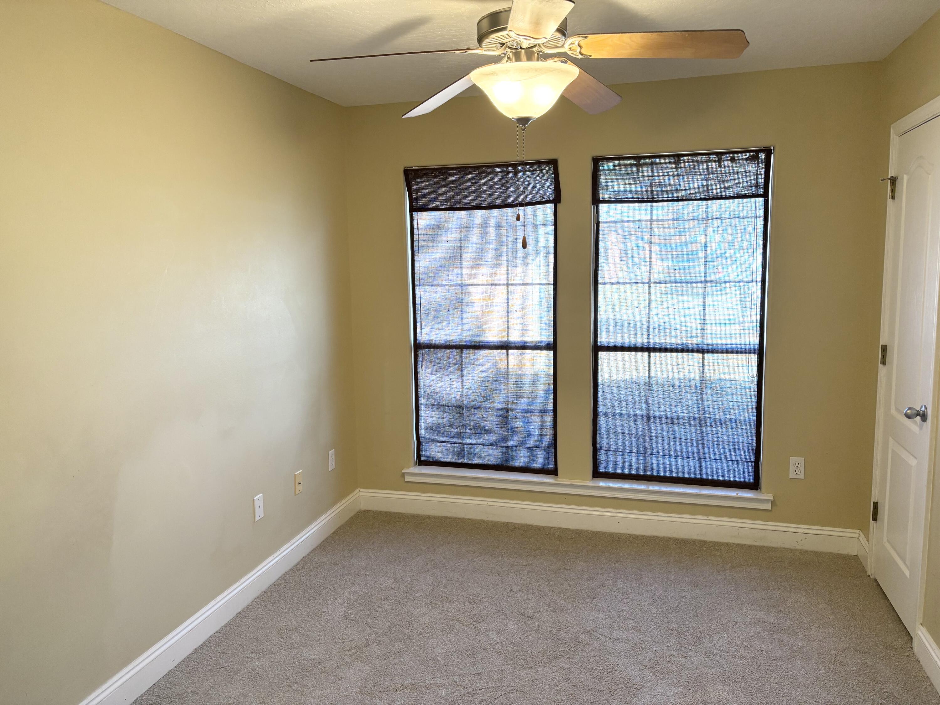 9561 Pouder Lane Navarre, FL 32566 - Photo 14 of 20 an empty room with chandelier fan and windows