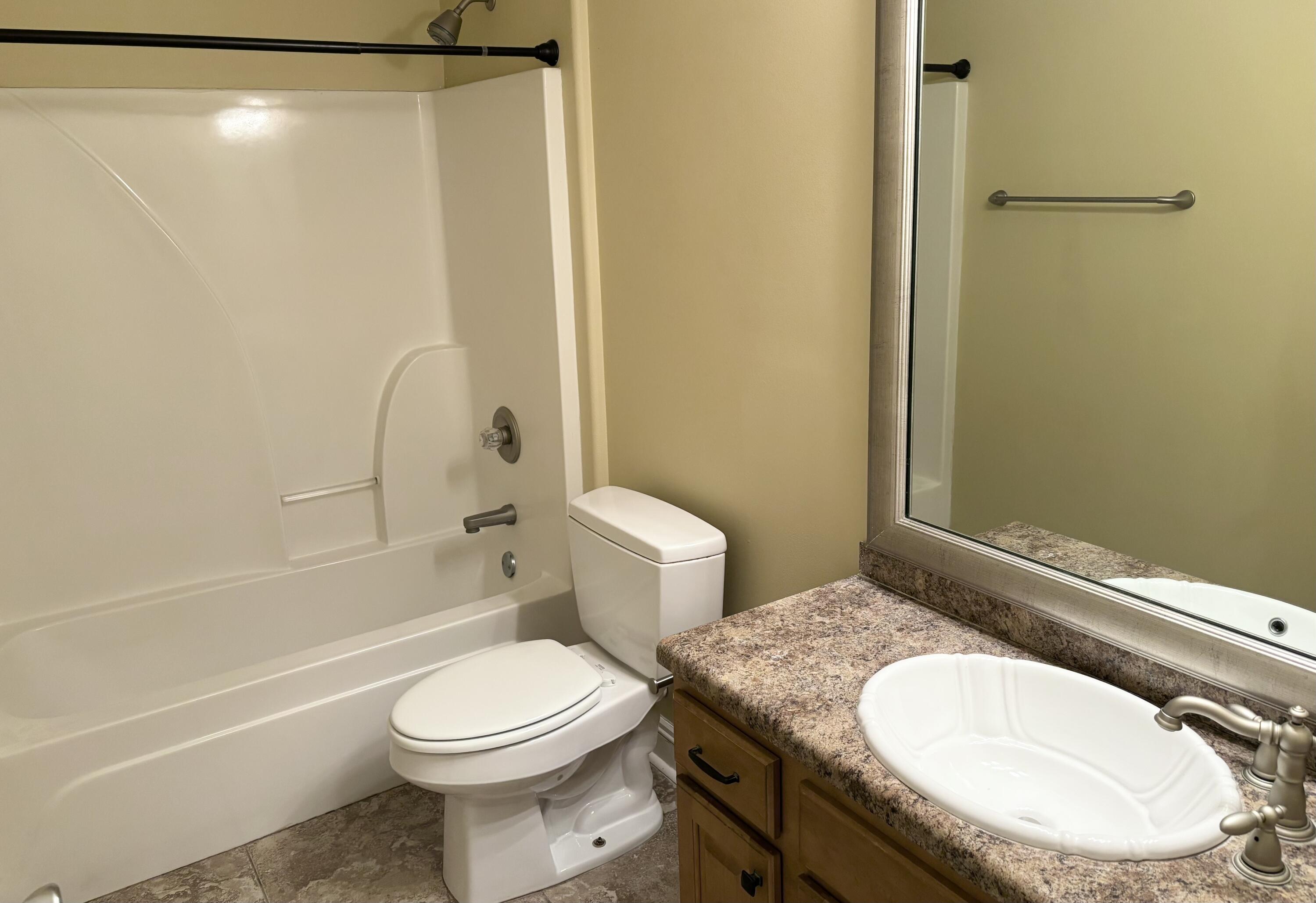 9561 Pouder Lane Navarre, FL 32566 - Photo 16 of 20 a bathroom with a granite countertop sink toilet and shower