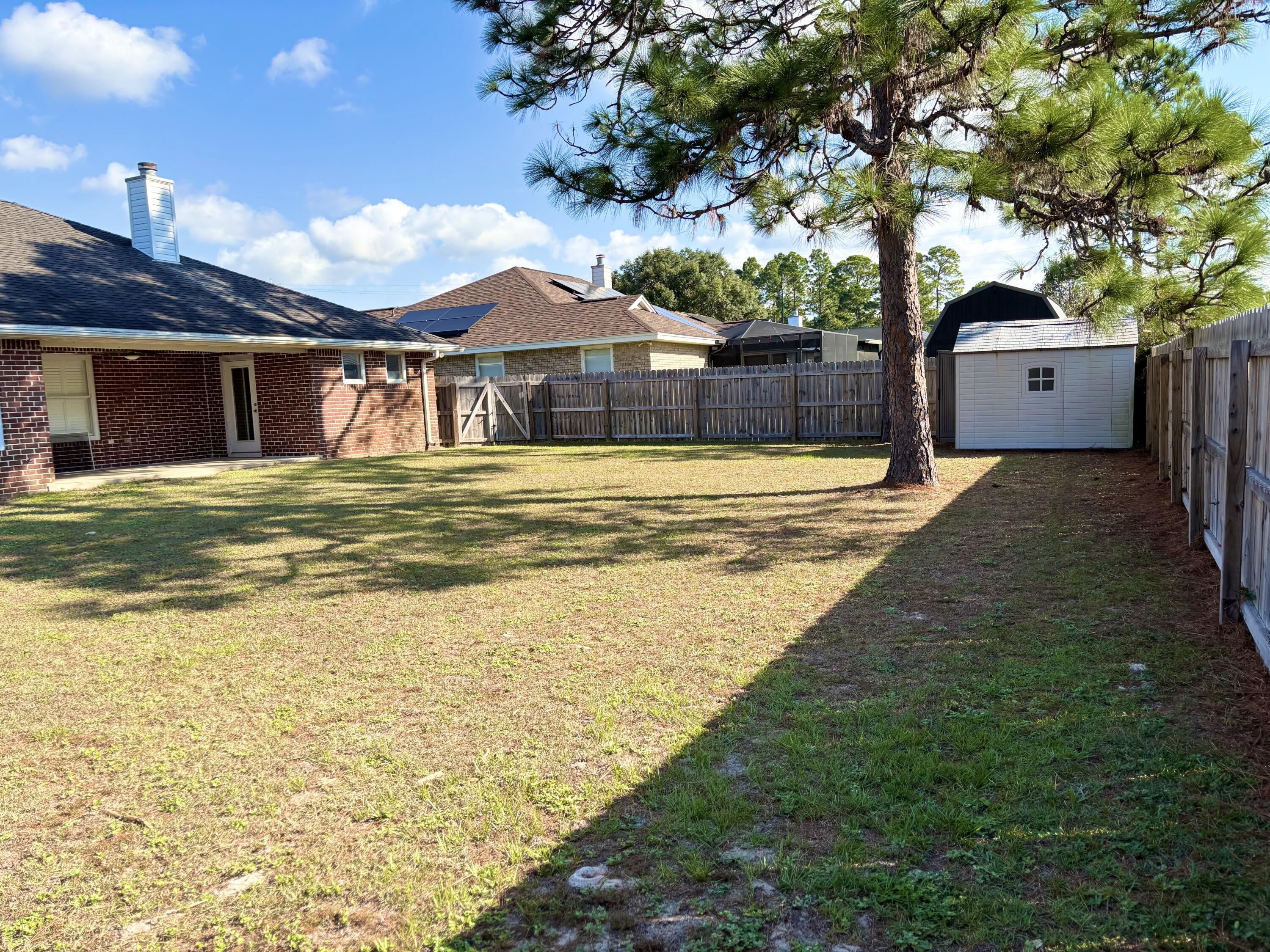 9561 Pouder Lane Navarre, FL 32566 - Photo 20 of 20 a view of a house with a swimming pool and a yard