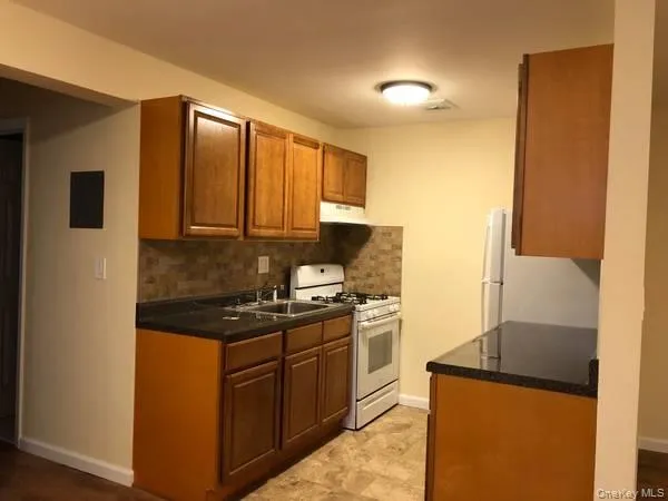 a kitchen with stainless steel appliances granite countertop a stove a sink and a refrigerator