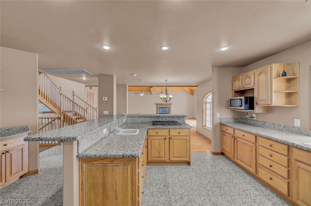 640 North Racetrack Road Henderson, NV 89015 - Photo 24 of 65 Granite counters and light wood cabinetry define this kitchen, opening to a spacious living area.